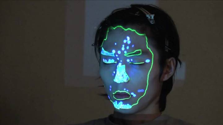 顔に、プロジェクションマッピング。顔の上に光の粒が映し出された。