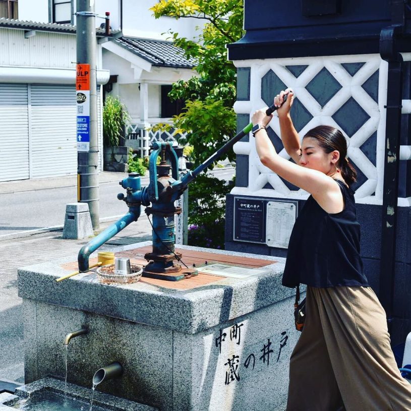 井戸で水を注ぐ嫁